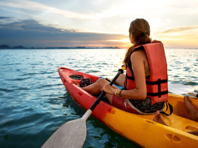 Couple kayaking together. Beautiful young couple kayaking on lake together and smiling at sunset